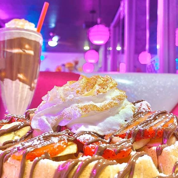 Beeps Diner waffle with strawberries, bananas, chocolate drizzle, whipped cream, and a milkshake.